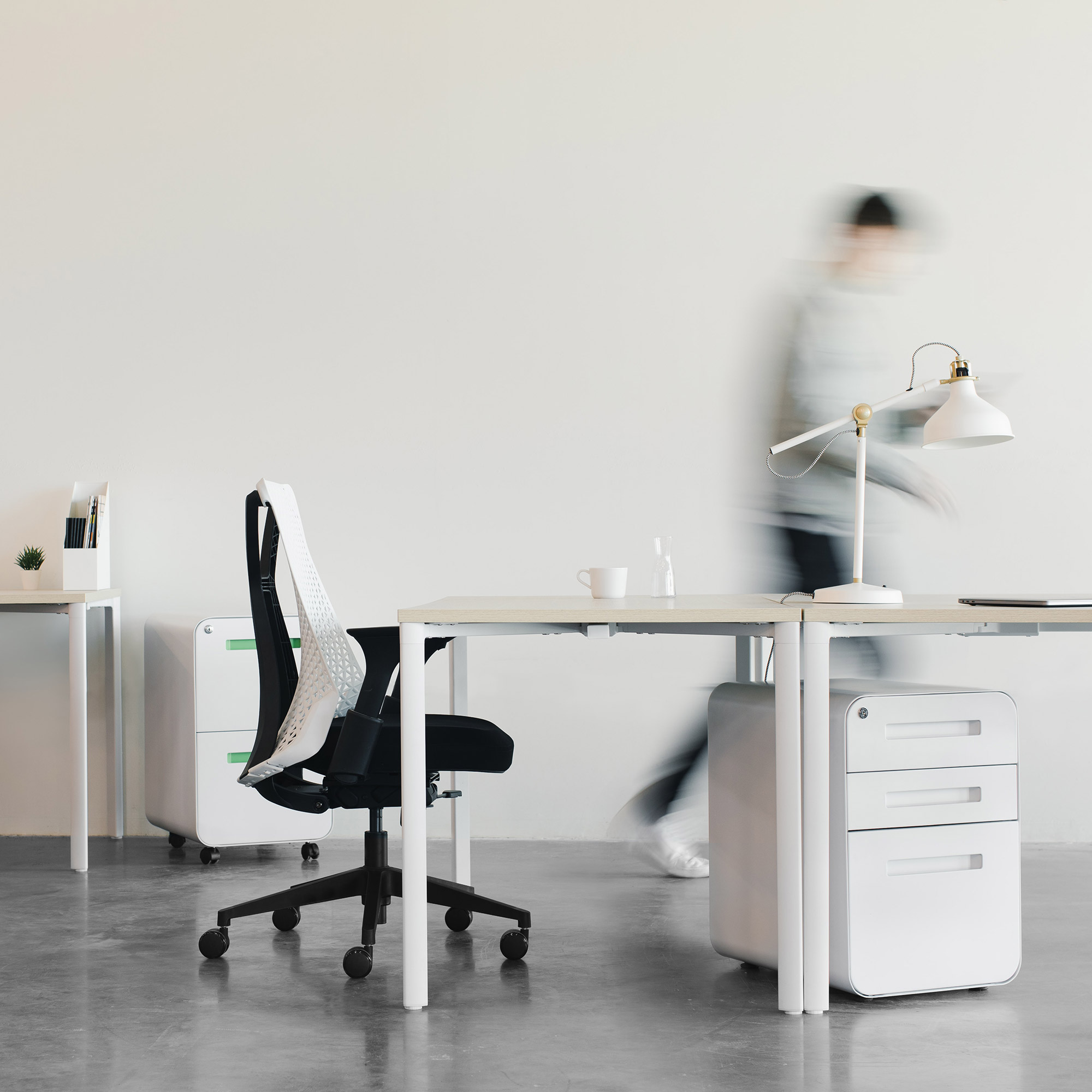 Photo: Person walking through a modern office.